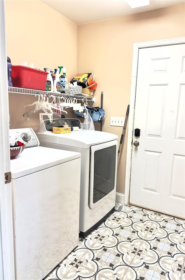 laundry area featuring light tile patterned flooring and washing machine and clothes dryer