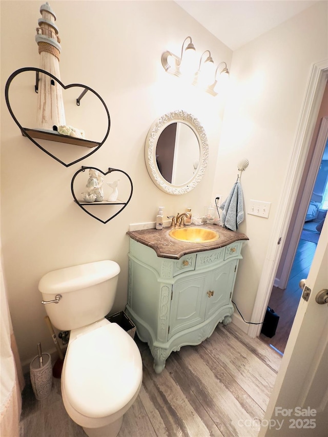 bathroom featuring hardwood / wood-style flooring, vanity, and toilet