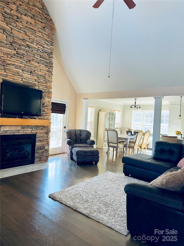 living room featuring ceiling fan, wood-type flooring, a stone fireplace, and high vaulted ceiling