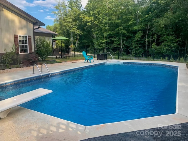 view of pool featuring a patio area and a diving board