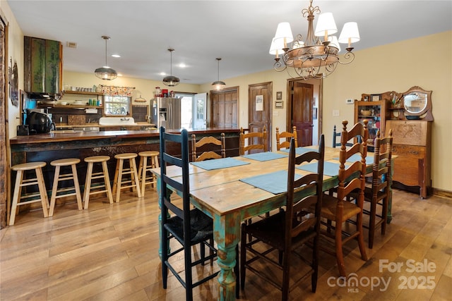 dining room featuring a chandelier and light wood-type flooring