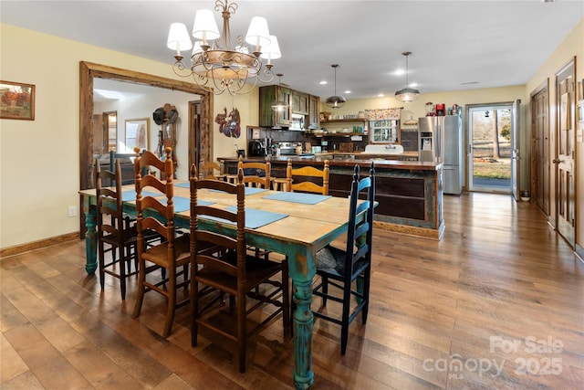 dining area with a notable chandelier and light hardwood / wood-style floors