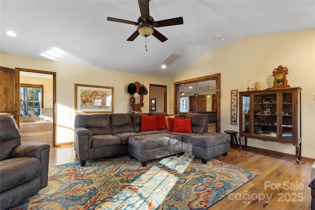 living room featuring ceiling fan, vaulted ceiling, and light wood-type flooring