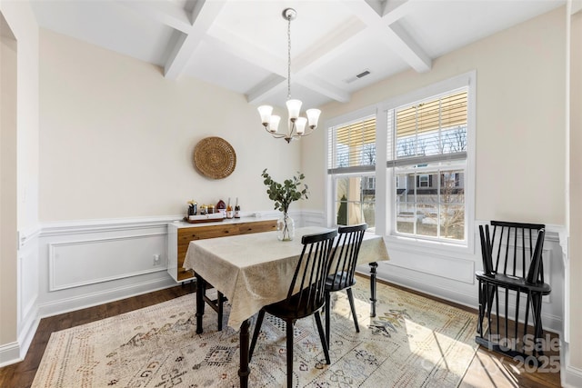 dining area featuring an inviting chandelier, hardwood / wood-style floors, beam ceiling, and coffered ceiling