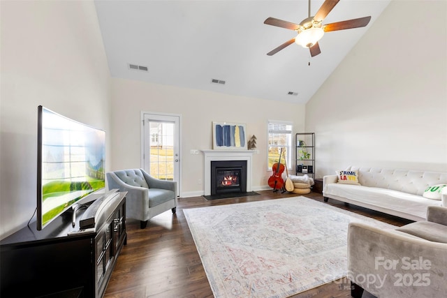 living room featuring ceiling fan, dark hardwood / wood-style floors, high vaulted ceiling, and a wealth of natural light