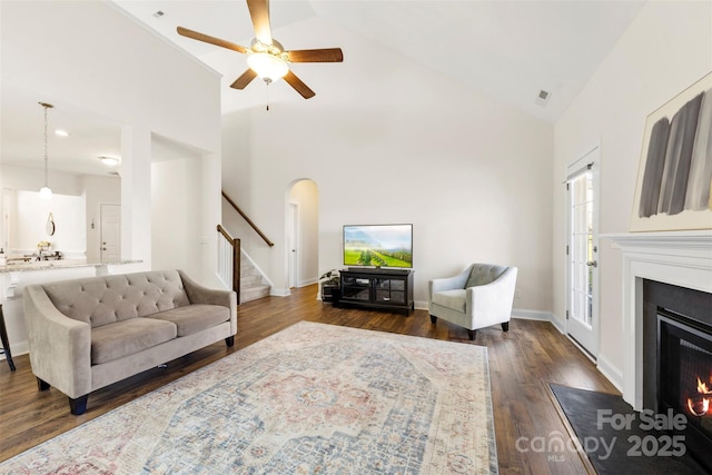 living room with dark wood-type flooring, high vaulted ceiling, and ceiling fan