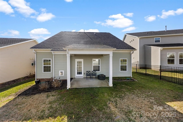 back of house with a patio and a lawn