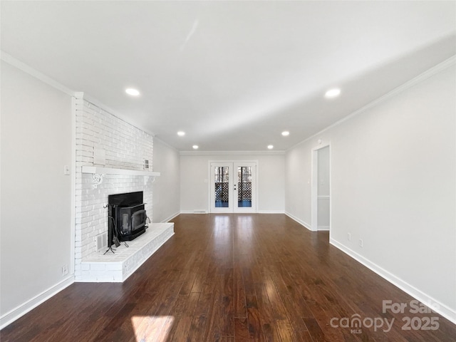 unfurnished living room featuring french doors, ornamental molding, dark hardwood / wood-style flooring, and a wood stove