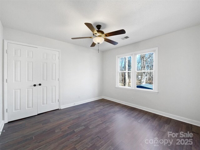 empty room with dark hardwood / wood-style flooring and ceiling fan