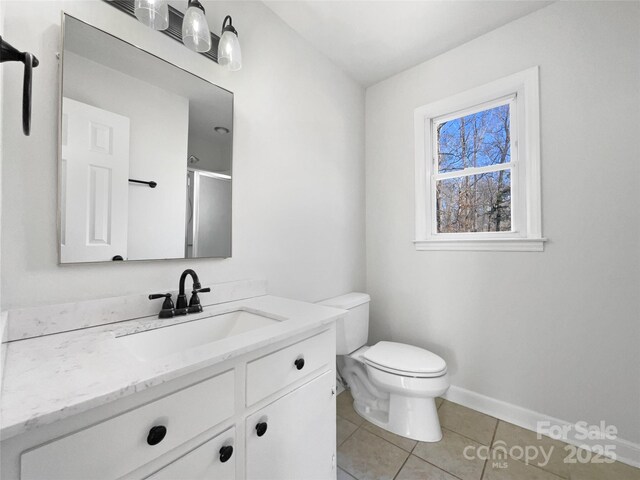 bathroom featuring vanity, toilet, tile patterned floors, and a shower with shower door