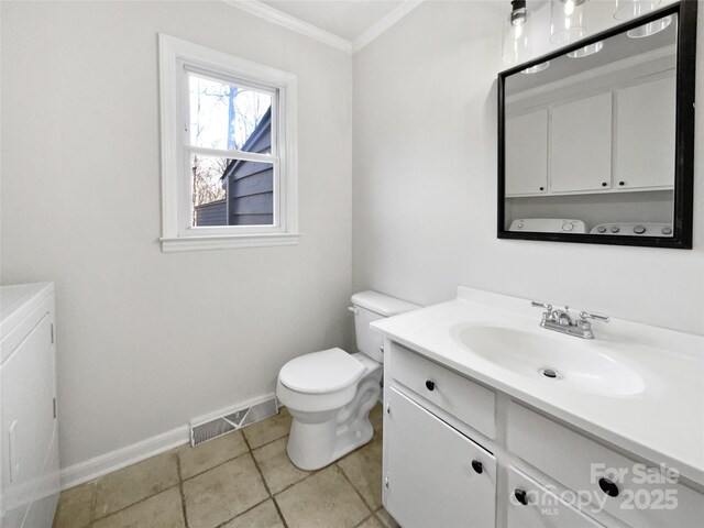 bathroom with ornamental molding, vanity, toilet, and washer and dryer