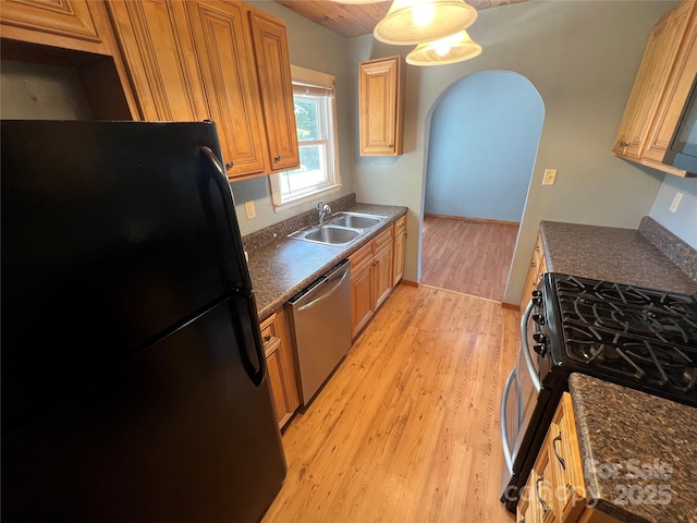 kitchen featuring stainless steel appliances, sink, and light hardwood / wood-style floors