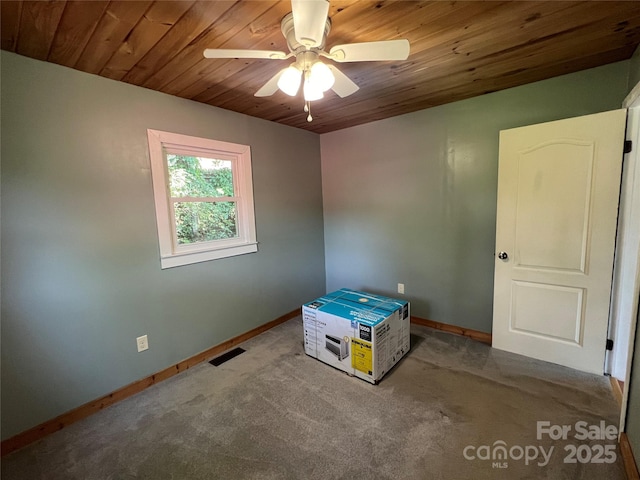 carpeted spare room with ceiling fan and wooden ceiling