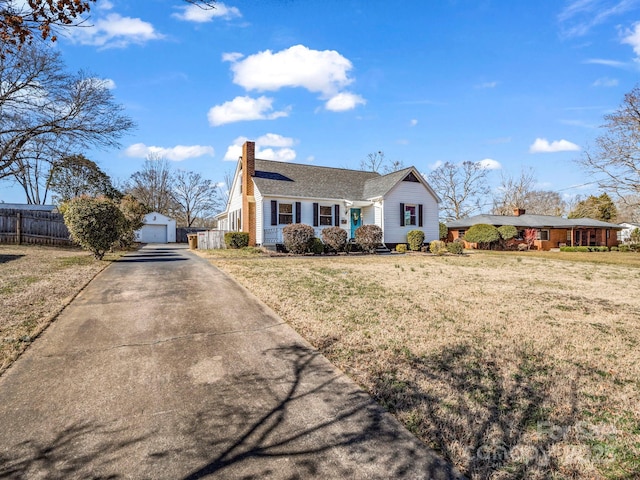 ranch-style home with a garage, an outdoor structure, and a front yard