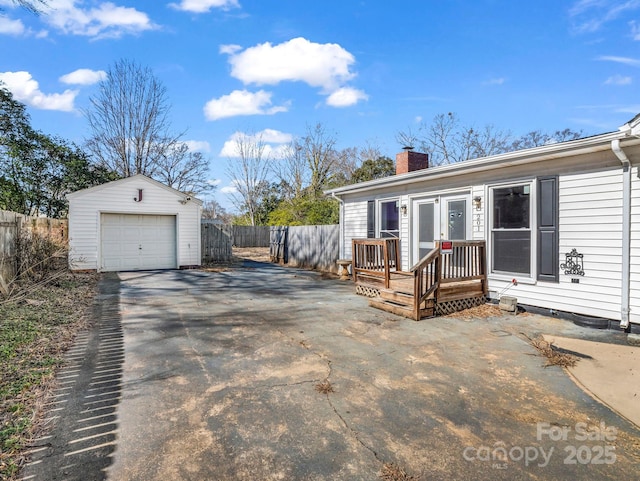 view of front of home with a garage and an outbuilding