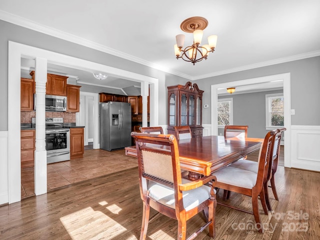 dining space with an inviting chandelier, dark wood-type flooring, and ornamental molding