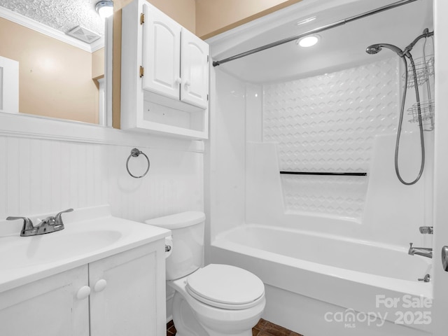 full bathroom with vanity, ornamental molding,  shower combination, toilet, and a textured ceiling