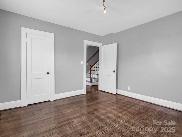 unfurnished room with dark wood-type flooring