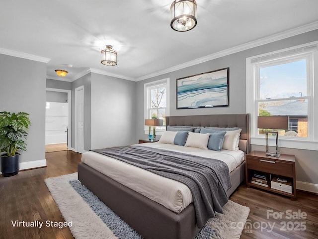 bedroom featuring crown molding, connected bathroom, baseboards, and wood finished floors