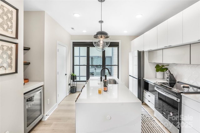 kitchen with wine cooler, a kitchen island with sink, stainless steel electric stove, open shelves, and pendant lighting