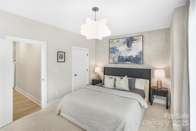 bedroom with an inviting chandelier and baseboards