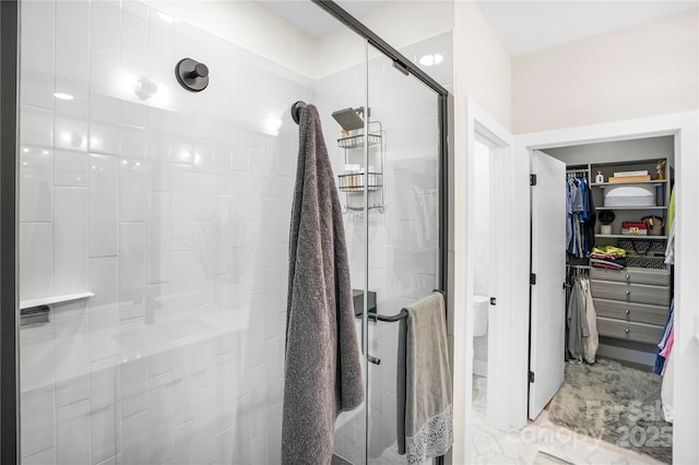 bathroom with a stall shower and a walk in closet