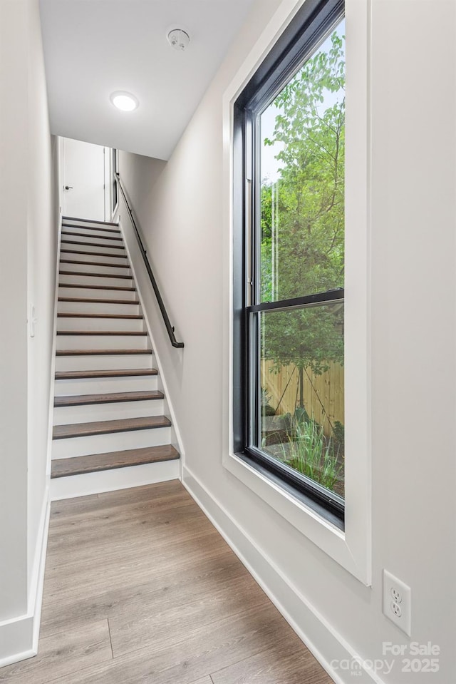 staircase with baseboards and wood finished floors