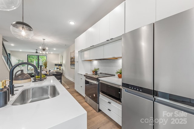 115 Verbena St NE Unit 12, Charlotte, NC 28217 - kitchen with appliances with stainless steel finishes, a sink, light countertops, white cabinetry, and open floor plan