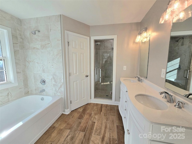 bathroom with hardwood / wood-style flooring, vanity, and shower with separate bathtub