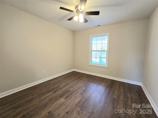 spare room with dark wood-type flooring and ceiling fan