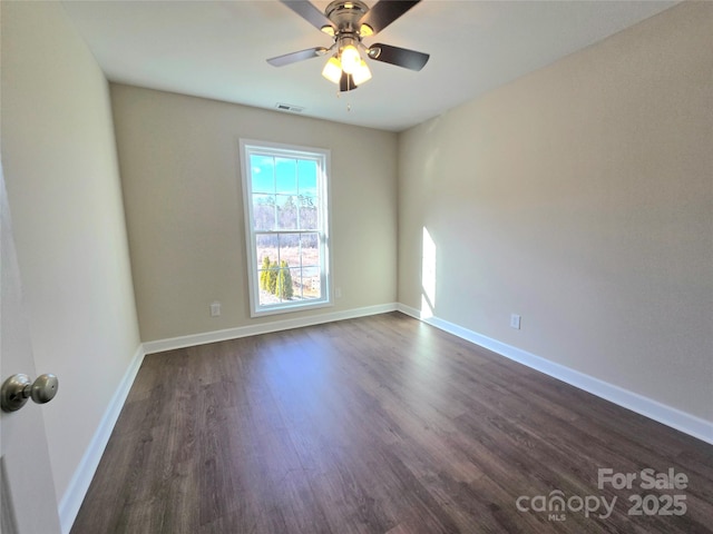 spare room featuring dark wood-type flooring and ceiling fan