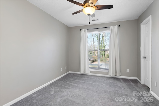 spare room featuring ceiling fan and carpet