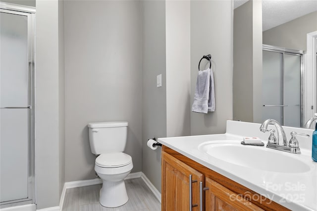 bathroom with vanity, an enclosed shower, and toilet