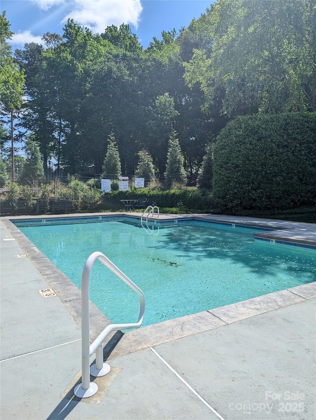 community pool featuring fence and a patio