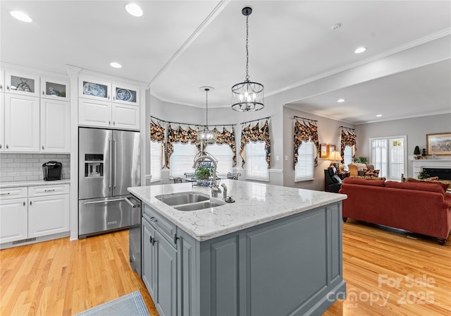 kitchen with appliances with stainless steel finishes, gray cabinets, pendant lighting, a kitchen island with sink, and white cabinets