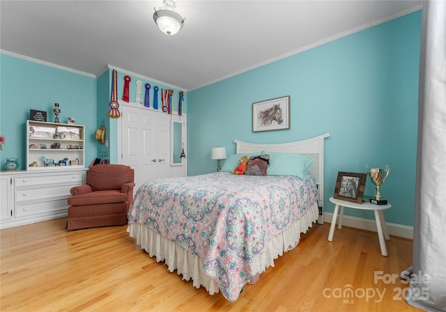 bedroom with crown molding, a closet, and light wood-type flooring