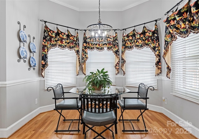 dining area with crown molding, wood-type flooring, and a chandelier