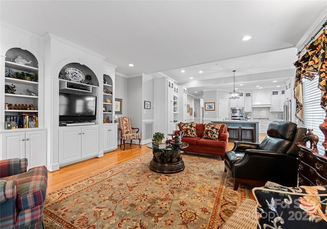 living room featuring crown molding and light hardwood / wood-style flooring