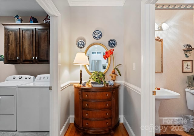 laundry room featuring cabinets, ornamental molding, and washing machine and dryer