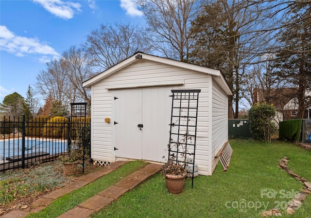 view of outbuilding featuring a yard and a covered pool