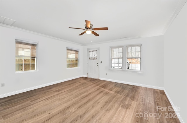 empty room featuring light wood-style flooring, baseboards, ceiling fan, and crown molding