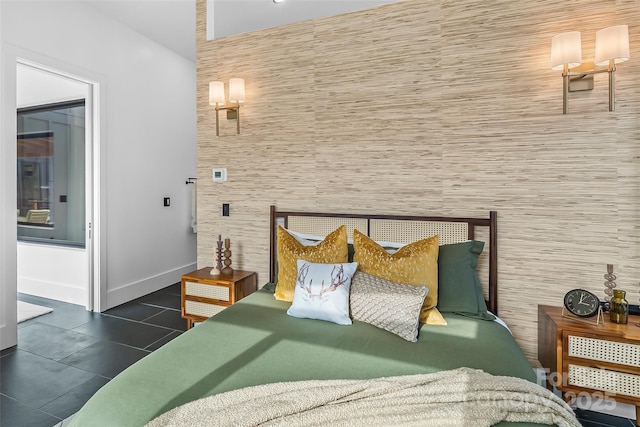 bedroom featuring dark tile patterned floors and ensuite bath