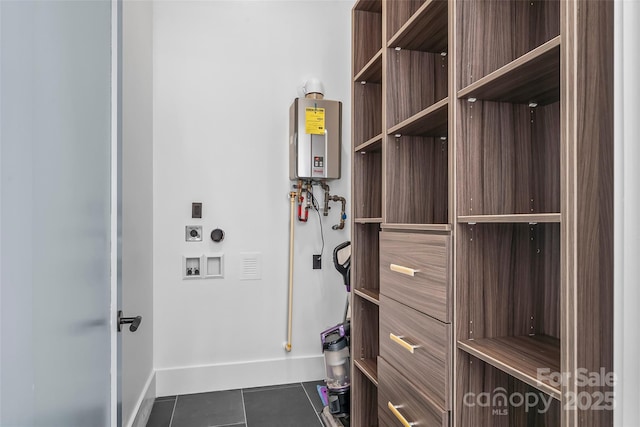 interior space featuring dark tile patterned floors, electric dryer hookup, washer hookup, and tankless water heater