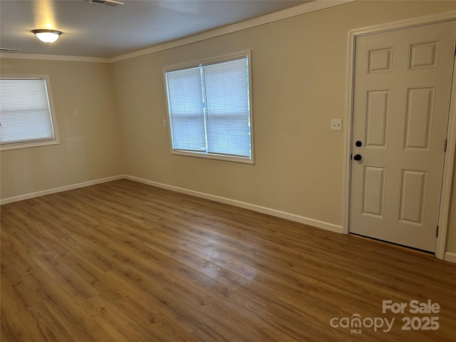 foyer entrance with ornamental molding and hardwood / wood-style floors