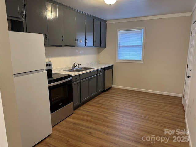 kitchen featuring sink, gray cabinets, stainless steel appliances, and light wood-type flooring