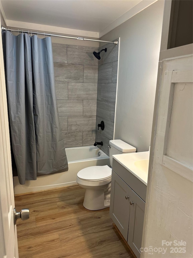 full bathroom featuring hardwood / wood-style flooring, vanity, shower / bath combination with curtain, and toilet