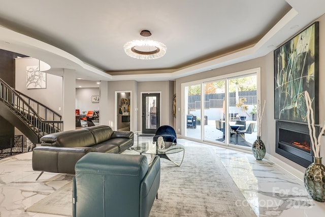 living room with a large fireplace and a raised ceiling