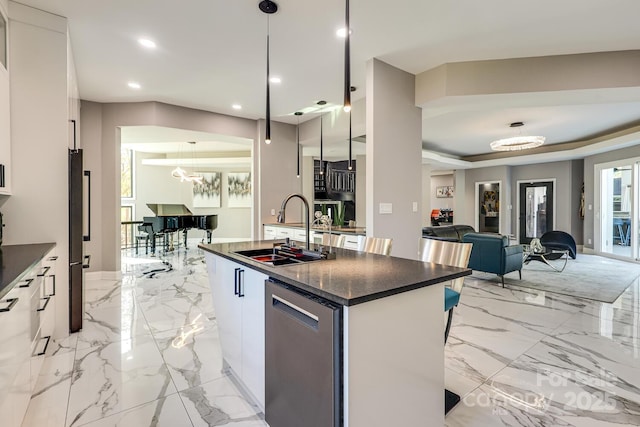 kitchen with sink, decorative light fixtures, stainless steel dishwasher, an island with sink, and white cabinets