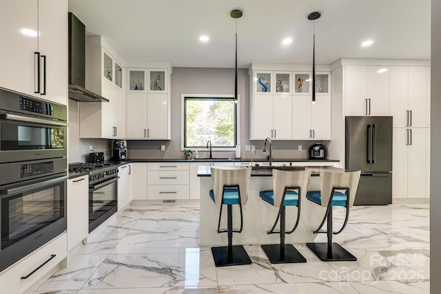 kitchen with white cabinetry, high quality fridge, pendant lighting, stainless steel double oven, and wall chimney range hood