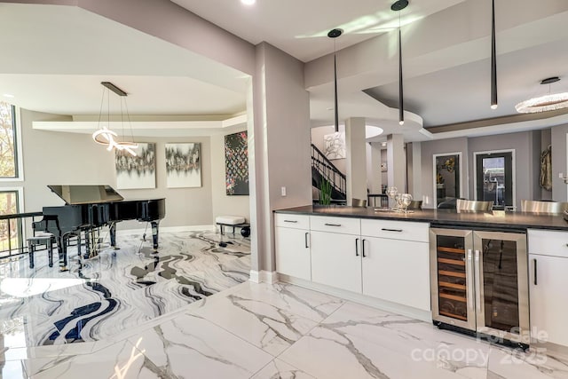 bar featuring wine cooler, a tray ceiling, a wealth of natural light, pendant lighting, and white cabinets